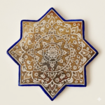 Handcrafted Persian lustreware star tile in Ilkhanid style featuring a golden medallion motif, created in Winter 2025 by the Tavasolian Brothers Workshop